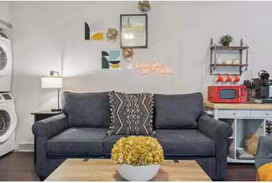Living room with stacked washing machine and drye