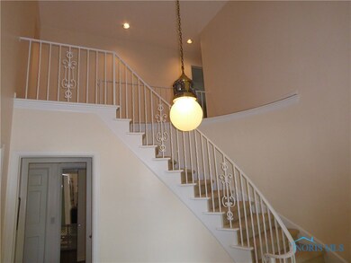 Large foyer with curved staircase to four upper le