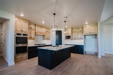 Kitchen with a kitchen island with sink, hanging l