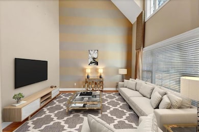 Living room with wood-type flooring and high vault