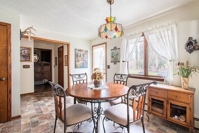 Dining room featuring a baseboard radiator, a textured ceiling, and dark tile flooring