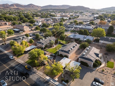 Aerial view of property and surrounding area featuring a mountain backdrop and nearby suburban area