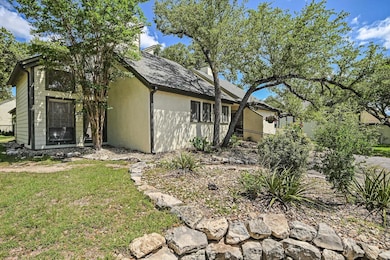 View of side of home featuring a chimney, stucco siding, and a lawn