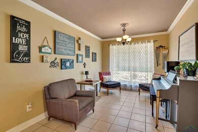 Living area featuring a chandelier, crown molding, and light tile patterned floors