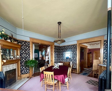 Tall ceilings, detailed woodwork, fireplace and antique light fixtures