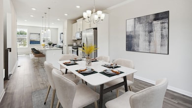 Dining room and Kitchen with LVP floors and large windows in a DRB Homes Alden Plan at the WestRidge at Westphalia Community