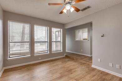 Empty room featuring ceiling fan, light hardwood / wood-style floors, and a textured ceiling