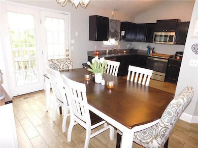 Dining area with lofted ceiling, visible vents, an