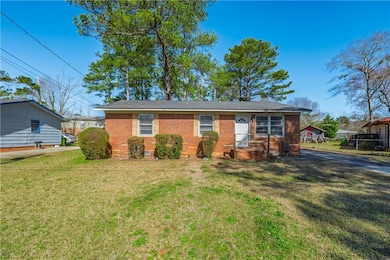 View of front of home featuring a front yard, brick siding, and crawl space