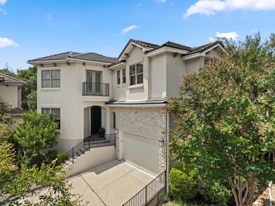 View of front of house with a balcony, stucco siding, a garage, driveway, and stone siding