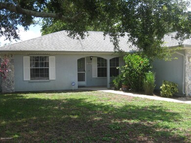Large shade tree and hibiscus in front