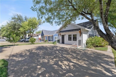 View of front of house featuring board and batten siding, a standing seam roof, a porch, and driveway