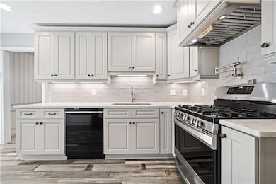 Kitchen featuring range hood, light countertops, d