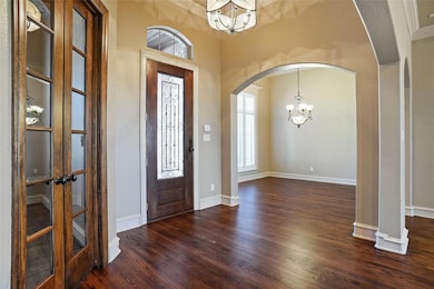 Foyer featuring an inviting chandelier, arched wal