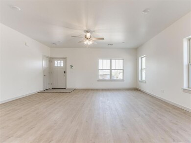 Unfurnished living room with baseboards, light woo