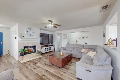 Living room featuring a fireplace, ceiling fan, li