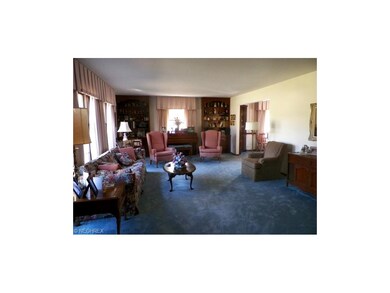 Spacious carpeted living room with four full windo