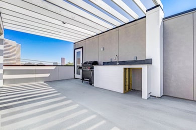Rooftop deck with an outdoor kitchen with a refrigerator and grill.