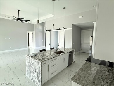 Kitchen with white cabinetry, dishwasher, an islan
