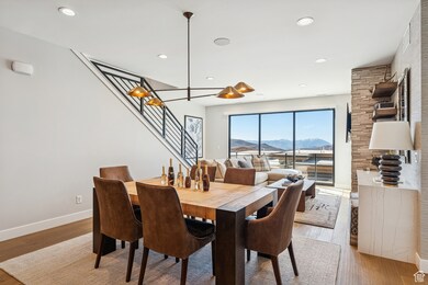 Dining area with a mountain view, wood finished floors, stairway, and recessed lighting
