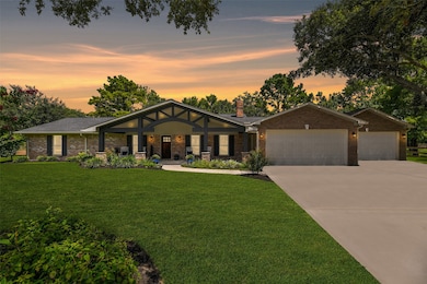 An extra-long paved driveway leads from Falling Leaf Drive amidst the towering trees that dot this property to this charming single-story home with ample parking space and a brick elevation with wood shutters and the most inviting gabled front porch.