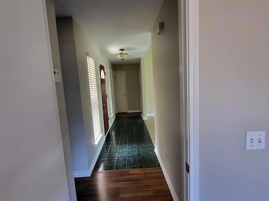 Hallway featuring baseboards and wood finished fl