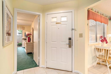 Foyer with a textured ceiling, baseboards, and light tile patterned floors