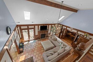 Living area featuring a brick fireplace, beam ceil