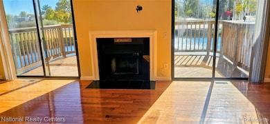 Living area featuring hardwood / wood-style floors and a fireplace with raised hearth