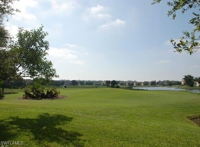 View of green lawn featuring view of golf course and a water view