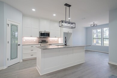 Kitchen with white cabinets, sink, a center island