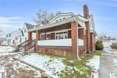 View of snowy exterior featuring a garage and a porch