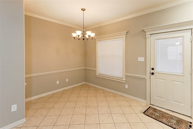 Entrance foyer with a chandelier, light tile patte