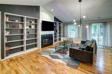 Living room has hardwood floors, vaulted ceiling a