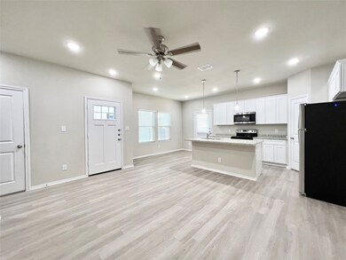Kitchen with appliances with stainless steel finishes, a kitchen island with sink, light wood-type flooring, a ceiling fan, and recessed lighting
