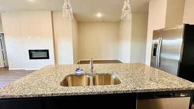 Kitchen with hanging light fixtures, a sink, light