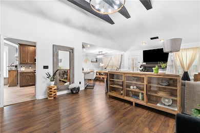 Living room featuring high vaulted ceiling, dark w
