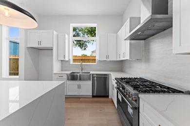 Kitchen features quartz waterfall island, stainles