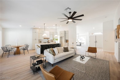 Living area with light wood-type flooring, a ceili