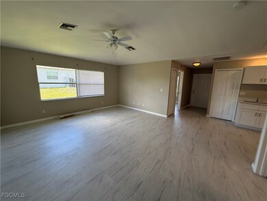 Unfurnished living room featuring baseboards and ceiling fan