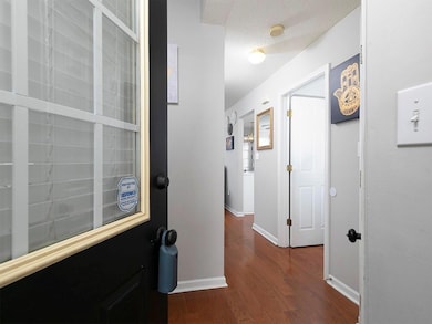 Hallway featuring dark wood-style floors and a textured ceiling