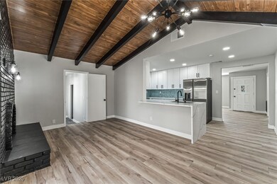 Kitchen with a chandelier, a peninsula, light wood