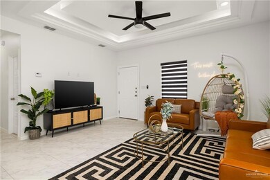Tiled living room with a raised ceiling and ceiling fan