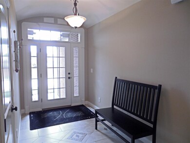 The foyer with custom tiled flooring has transom w