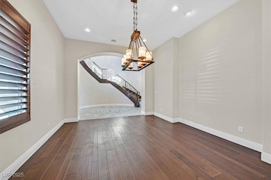 Spare room featuring a chandelier, arched walkways