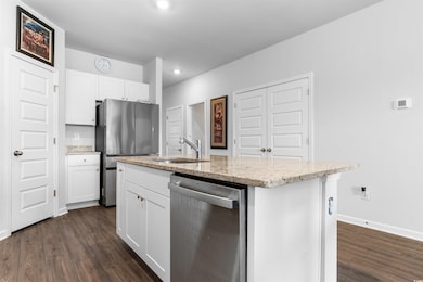 Kitchen with a center island with sink, white cabi