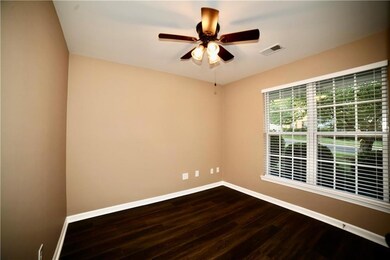 Unfurnished room with dark wood-style flooring and ceiling fan
