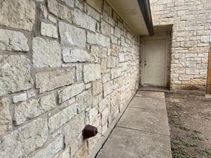 View of exterior entry featuring stone siding