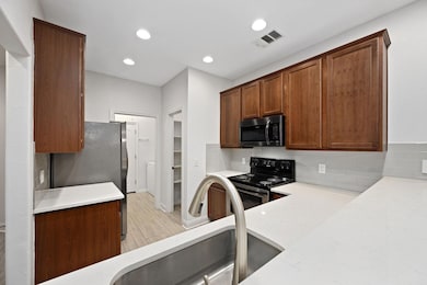 Kitchen with backsplash, stainless steel appliances, recessed lighting, light wood finished floors, and light stone counters