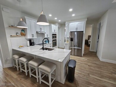 Kitchen with white cabinets, pendant lighting, kit